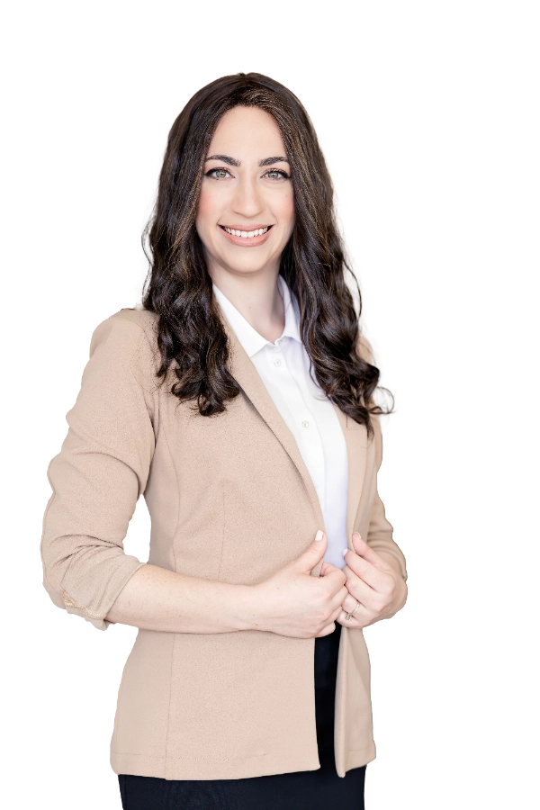 מירי ווינלס עומדת, מחזיקה את הג'קט ומחייכת למצלמה